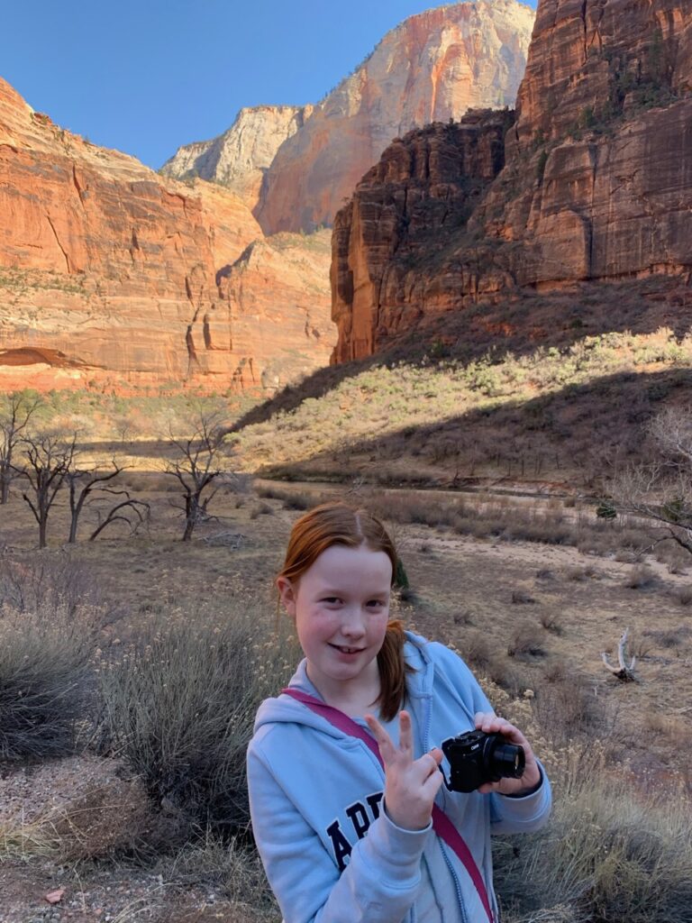 Cameron standing with her camera near the dry Pine Creek river bed, on the east side of Zion National Park.