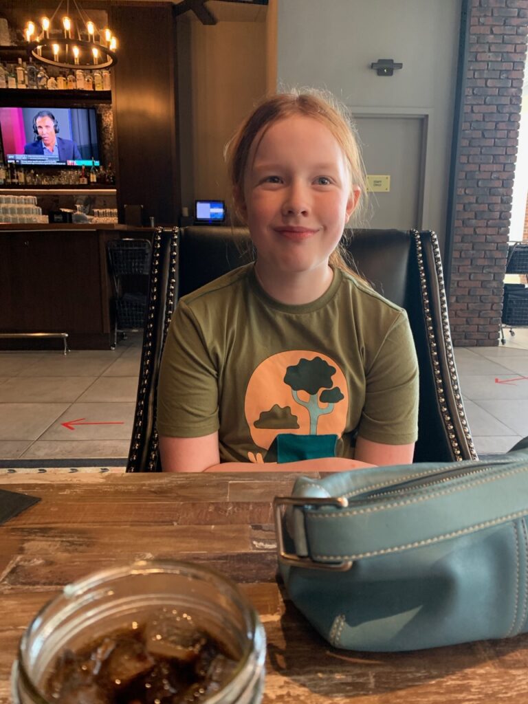 Cameron seated at a restaurant about to have dinner in Denver. 