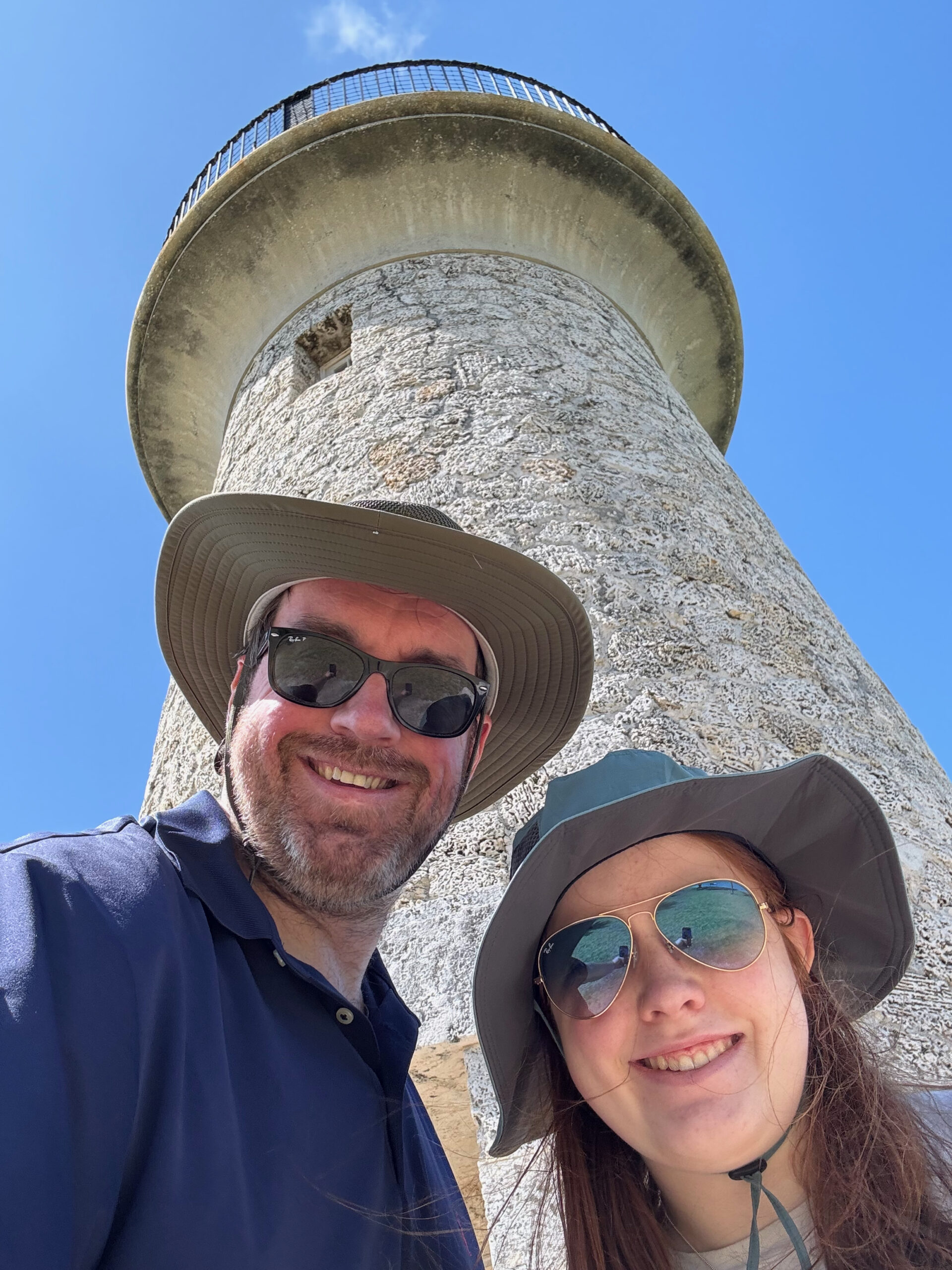 Cameron and myself both wearing hats and sunglasses take a selfie with the lighthouse behind us on Boca Chita Key.