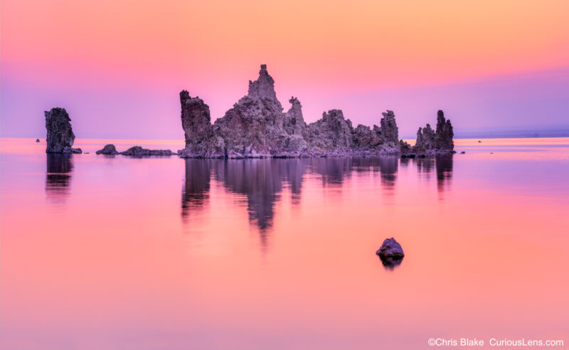 Mono Lake is a saline soda lake in Mono County, California. It features unique Tufa Towers formed by high salt levels. This 400-megapixel image captures the scene just before sunrise, with a calm lake surface reflecting the colorful clouds. The town of Lee Vining and Yosemite's high-country road lie nearby.