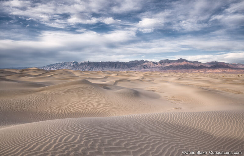 Late afternoon in Death Valley National Park on the Mesquite Flat Sand Dunes. Deep detailed sand texture, mountains in the background and a deep blue sky.