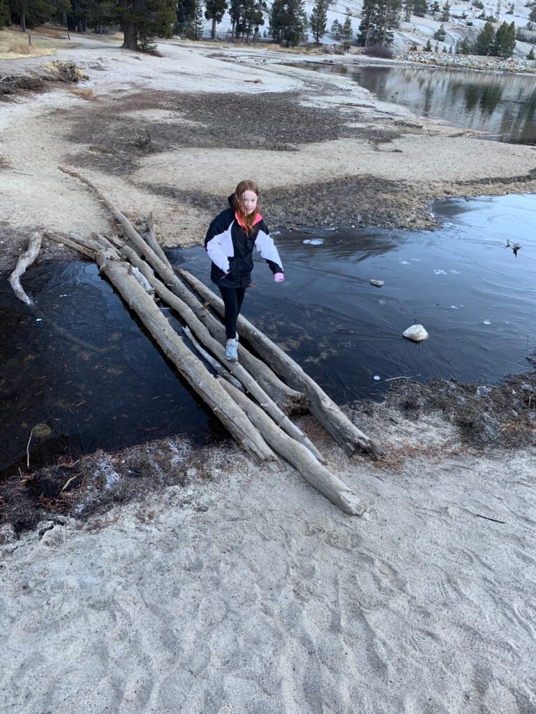 Cameron crossing a mostly frozen stream near Tenaya Lake in Yosemite National Park.