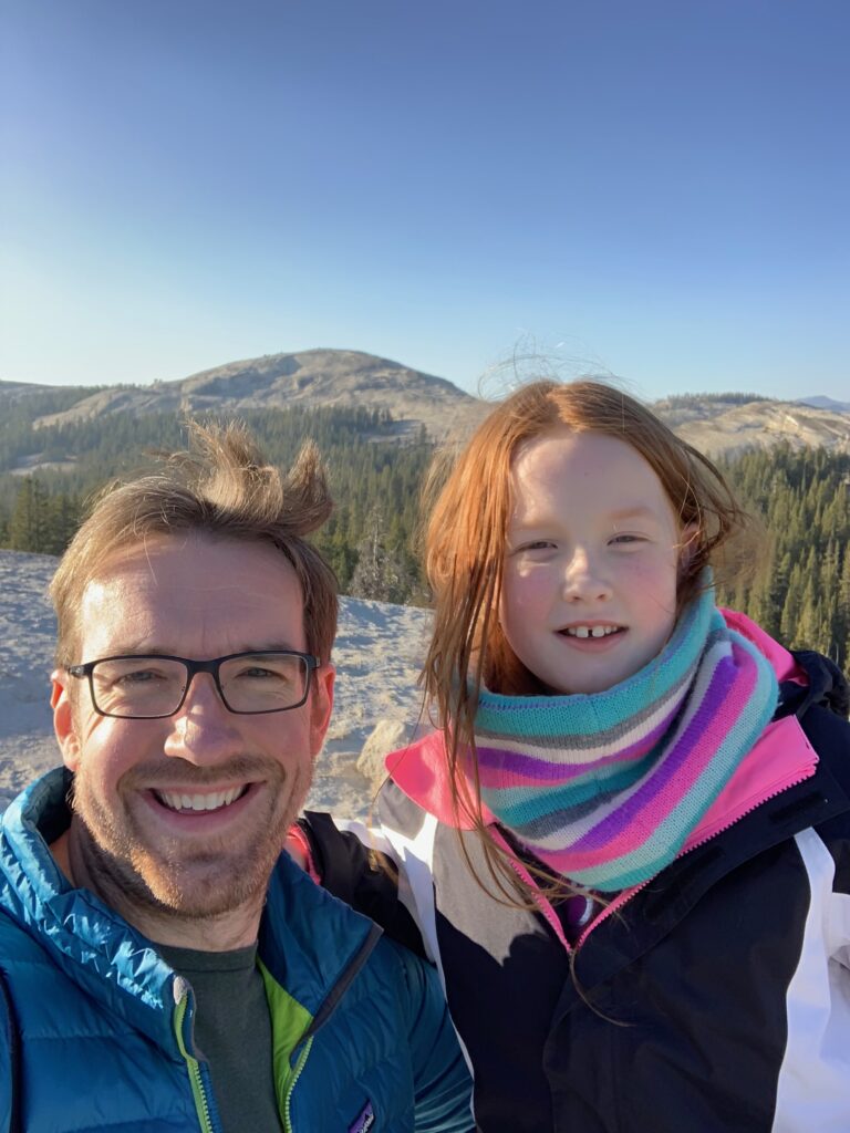 Cameron and Chris standing ontop of Pancake dome on a blue sky winters day in Yosemite National Park.