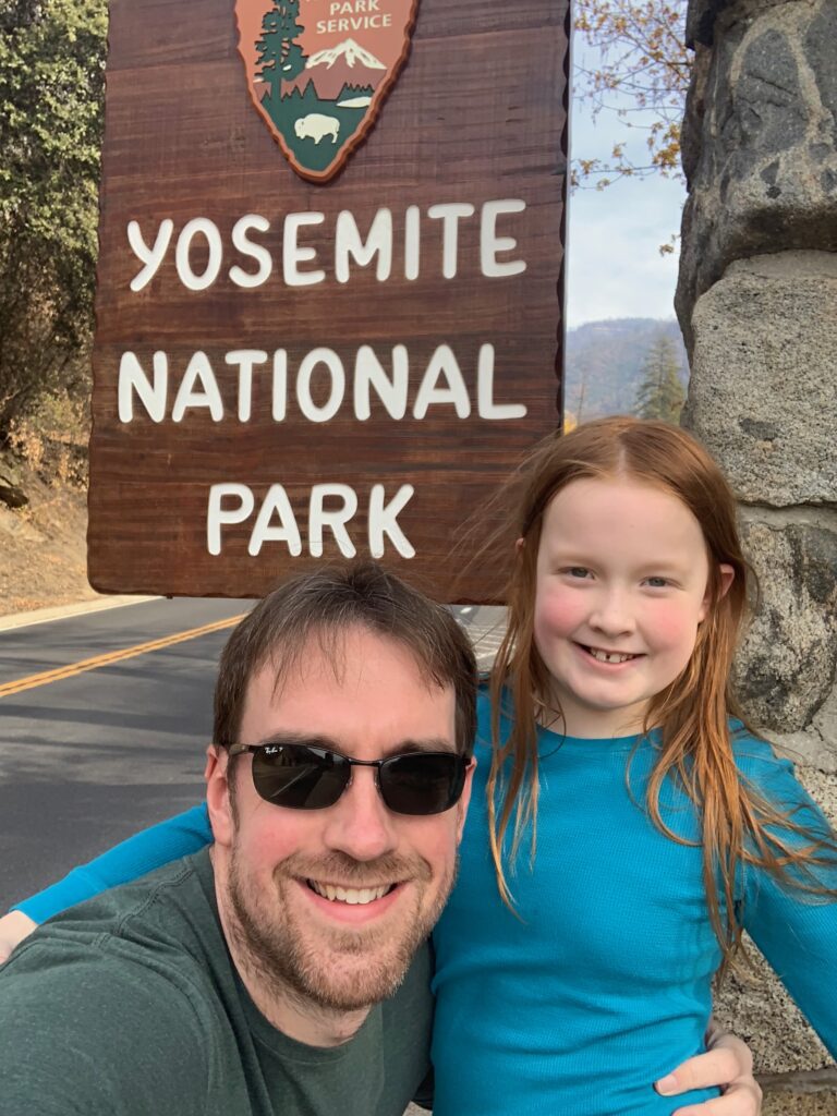 Cameron and Chris at the Yosemite National Park sign on the El Portal Rd next to the Merced River.