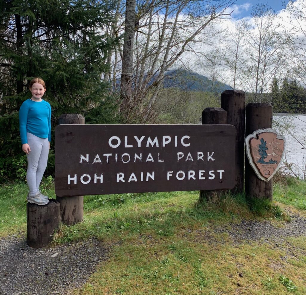 Cameron posing for a photo on the Olympic National Park sign.