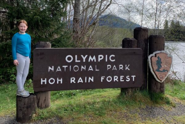 Cameron posing for a photo on the Olympic National Park sign.