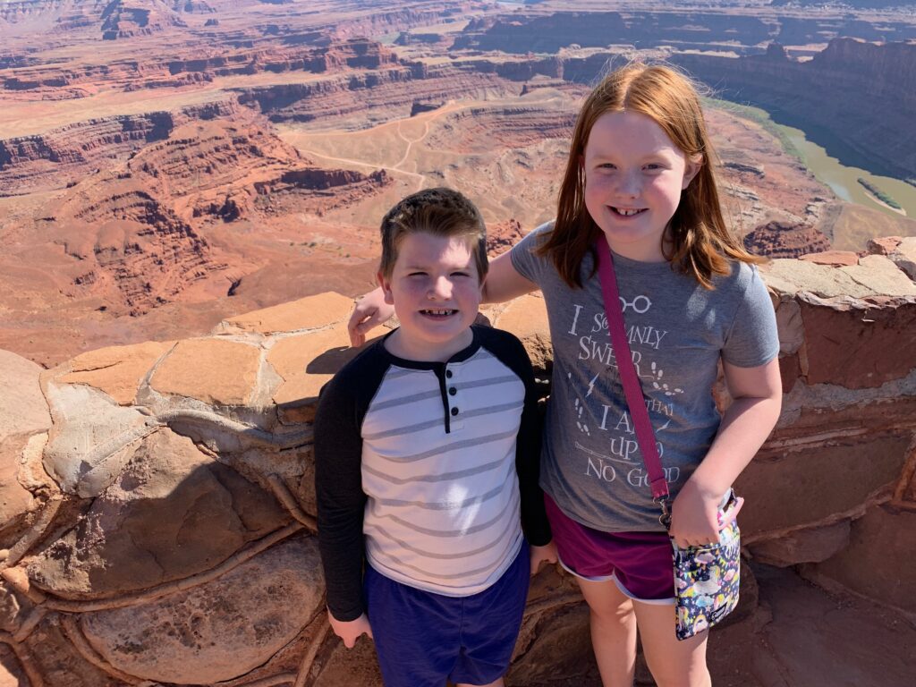 Cameron and Collin at the rock wall looking over the canyons at Dead Horse Point State Park in Utah.