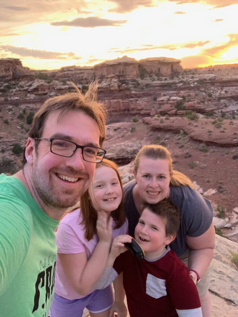 The entire family posing for a photo at sunset in Canyonlands National Park.