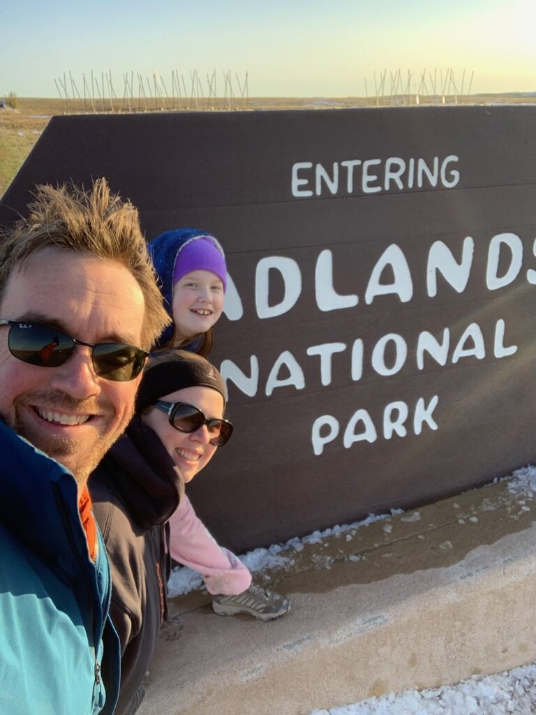 Cameron, Cat and myself in front of the park singe for Badlands National Park.