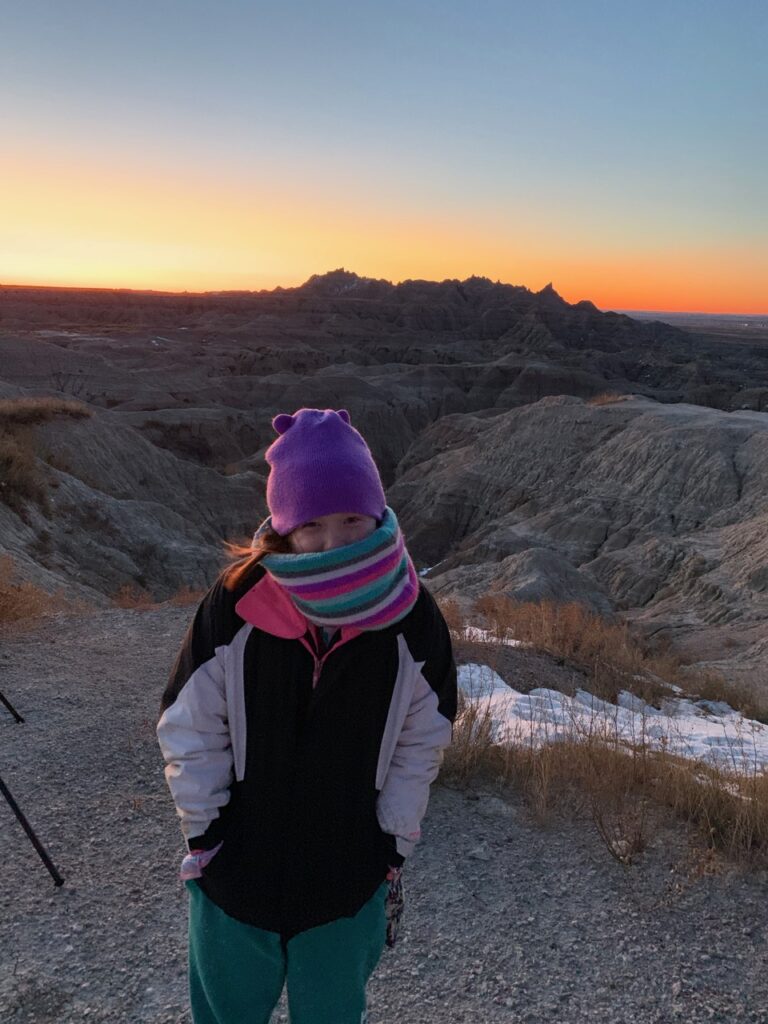 Cameron standing in the cold, very bundled up at a view point in Badlands National Park.