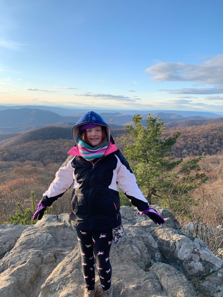 Cameron in Shenandoah National Park just after the peak of fall colors standing on rock overlooking the valley below. 