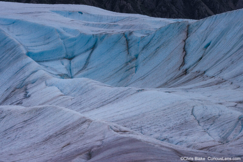 Root Glacier in Wrangell-St. Elias National Park, Alaska. Seven-photo blend showcasing diverse layers, captivating textures, leading lines, distinctive shapes, and deep blue ice under overcast skies.