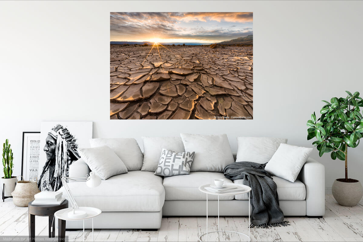 Death Valley sunset over cracked mud, print hung on wall.