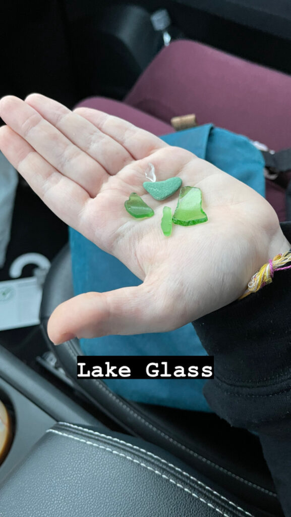 Cameron's open hand, while sitting in the car, showing the lake or sea glass that she had found on the beach of Lake Michigan.