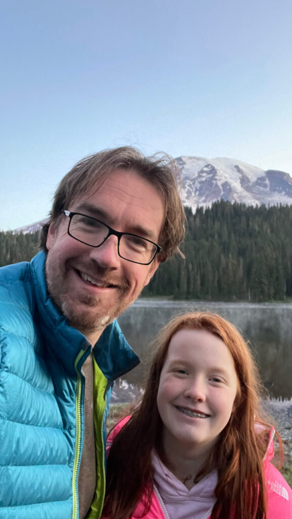 An early morning photo of Cami and myself taken at Reflection Lake - with the first light hitting the mountain behind us and fog is starting to come off the lake.