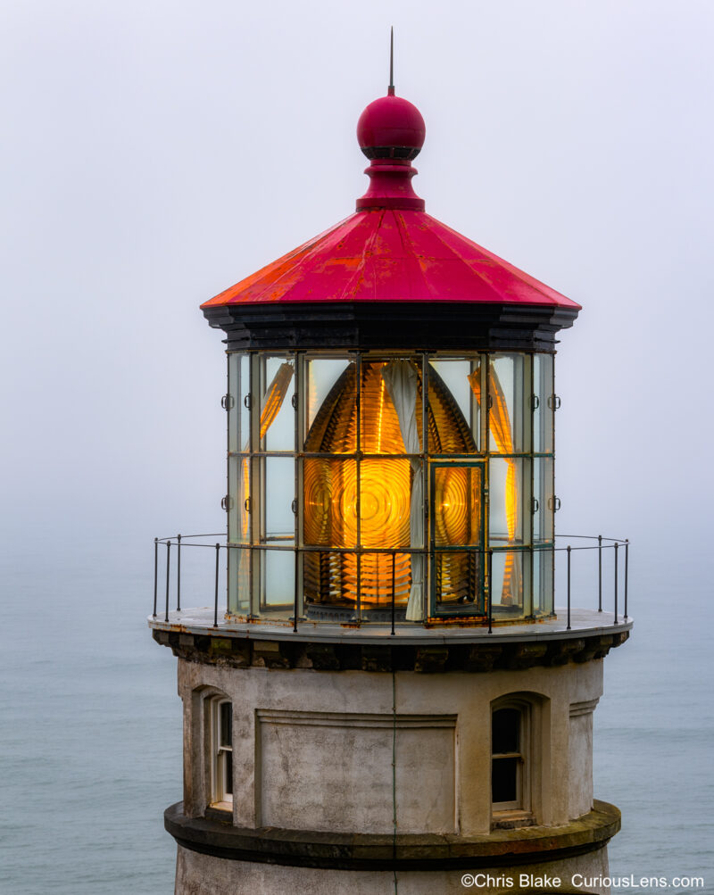 Heceta Head Light in Oregon, focusing on the lens and light, with rain, clouds, and fog removing distractions for a detailed view.