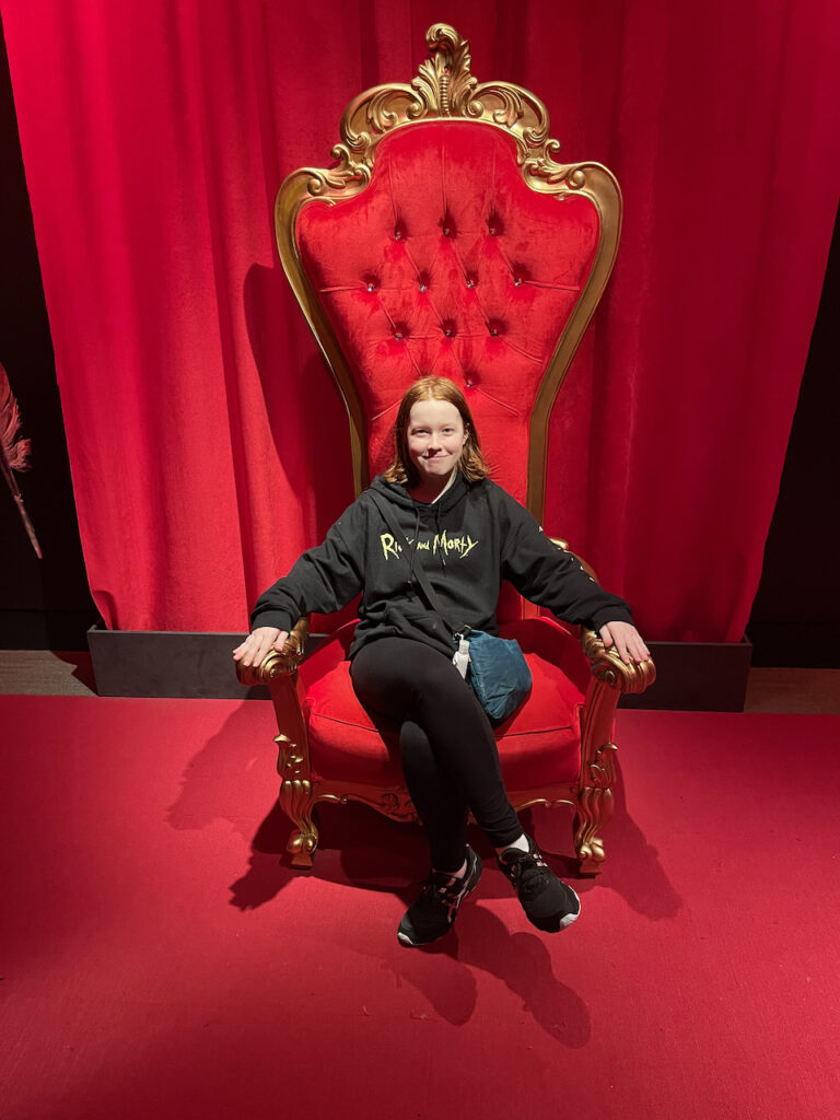 Cameron sitting in a giant red chair meant for a queen in the Field Museum. 