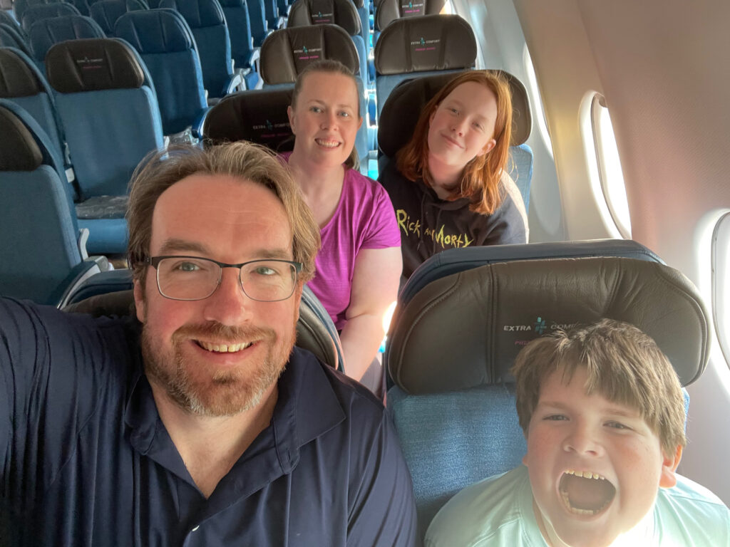 My entire family, Cat, Cameron, Collin, and myself sitting two by two on a Hawaiian airlines flight leaving from Boston. Everyone is all smiles expect for Collin who is making funny faces.