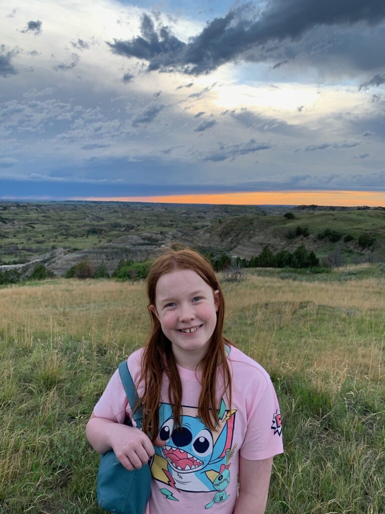 Cameron standing in the grasslands at sunset overlooking the badlands. 