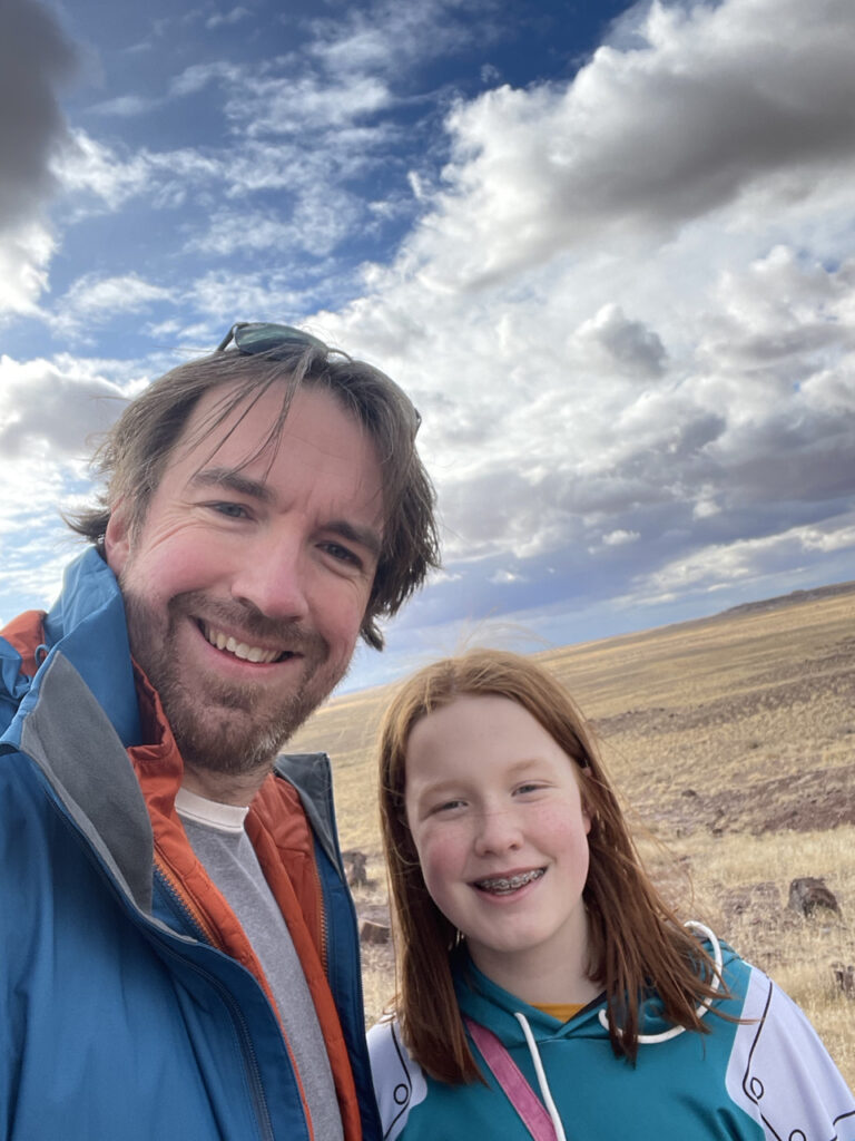 Cami and I on a wonderful day with epic clouds on trail near the Long Logs section of the Petrified Forest National Park.