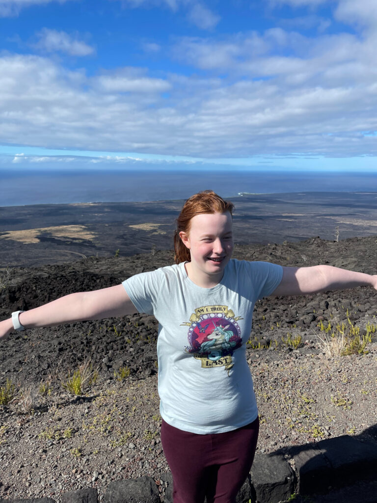 Cameron standing on a high overlook off the Chain of Craters Rd in Hawaii Volcanoes National Park with a stunning view of the Pacific Ocean.