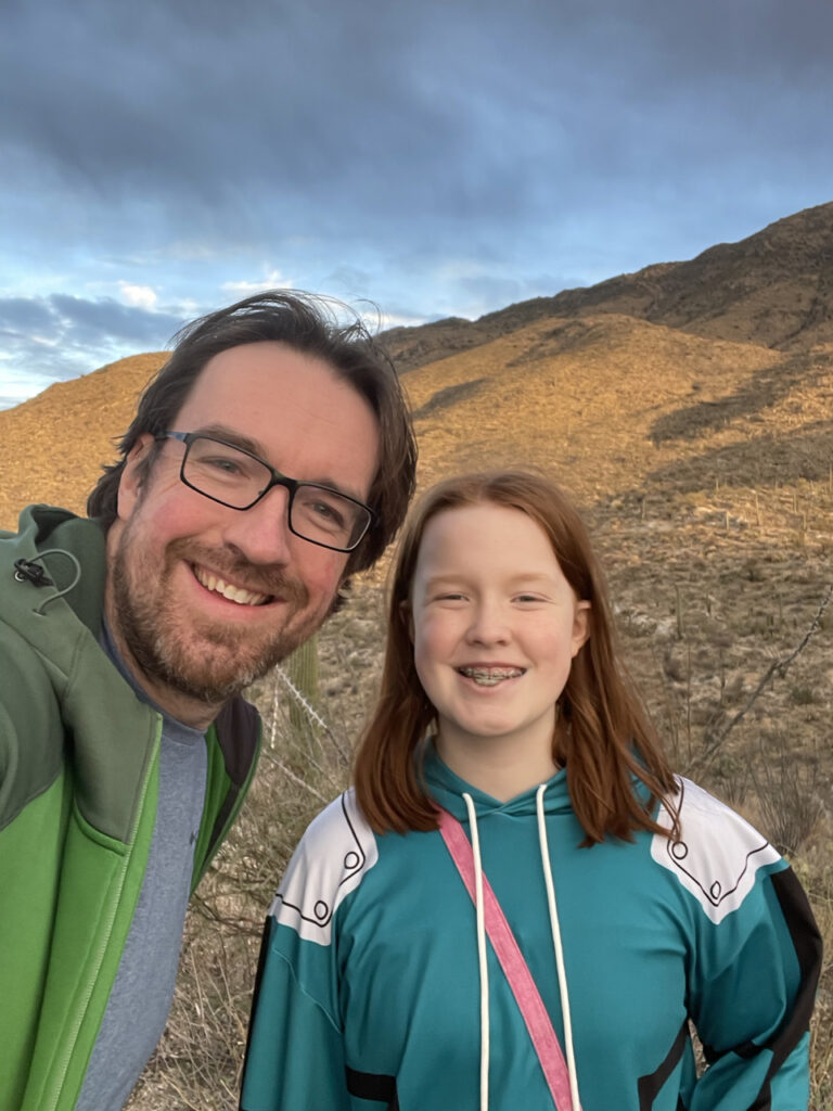 Cameron and myself at sunset with the last soft light of day cast on the mountain behind us, cloud breaking open overhead. 