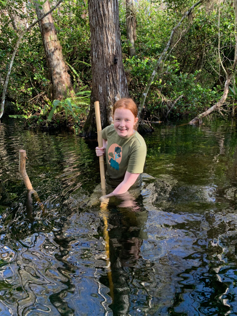 Cameron in deep water hiking in the everglades, using your hiking pole to test the dept to make sure its not over hear heard. 