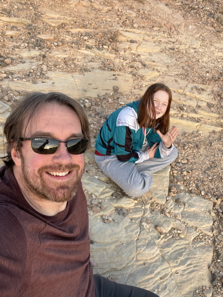 Cameron and myself sitting on the ground on the rocks in the desert waiting for sunset. Taken near the Silica Dome in the Valley of Fire State Park.