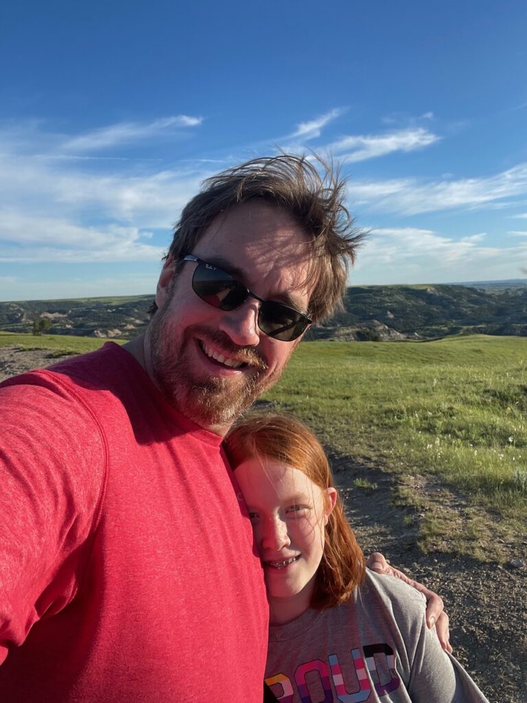 Cameron and myself in my bright red shirt, taken mid-day in the open grasslands of the park.