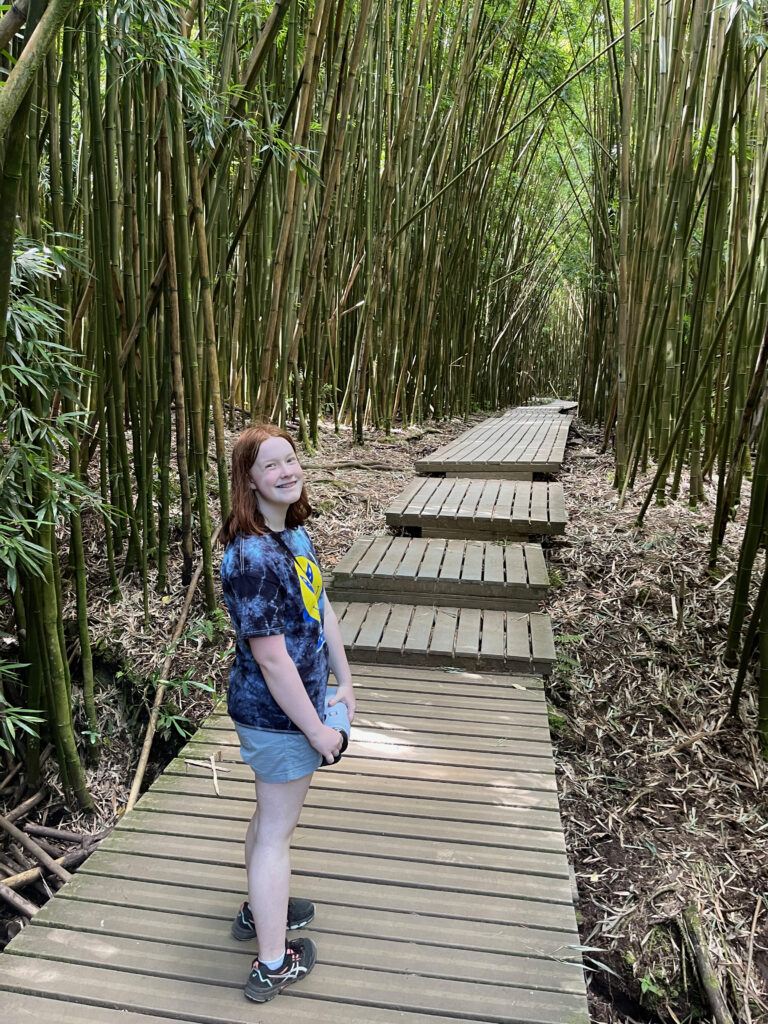 Cameron all smiles as she turns back to me, holding her water bottle standing on the boardwalk on the main section of the Bamboo forest in Pipiwai Trial inside Haleakala National Park.