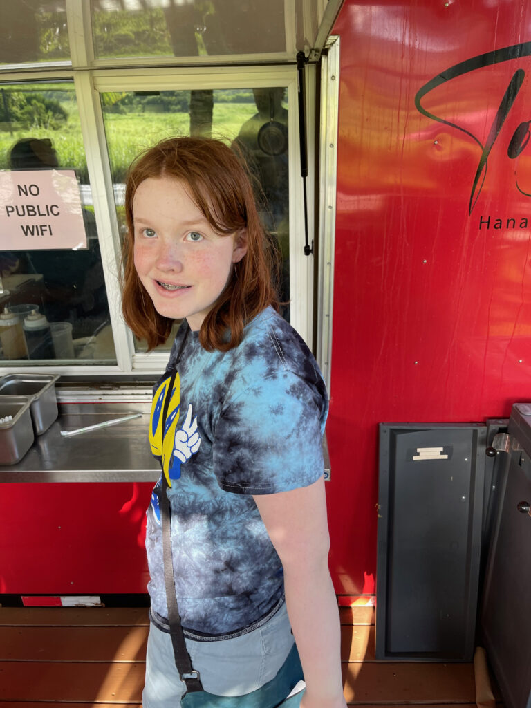 Cameron standing on a food truck right outside of Hana, waiting for her food after a long day of hiking. 