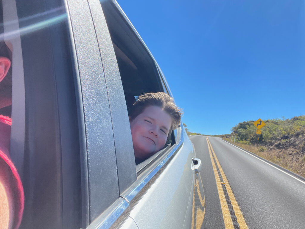 Collin in the backseat with his head out the window as we race down the Crater Rd down the Volcano in Kula. 