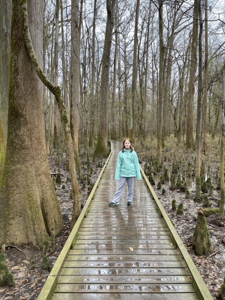 Cami wearing her rain coat hiking the Lower Boardwalk trail in the rain, in Congaree National Park.