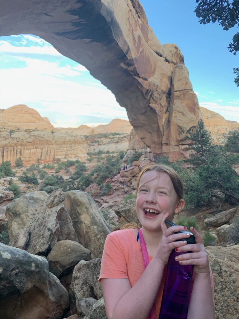 Cameron standing right under the Hickman Natural bridge in Capitol Reef.