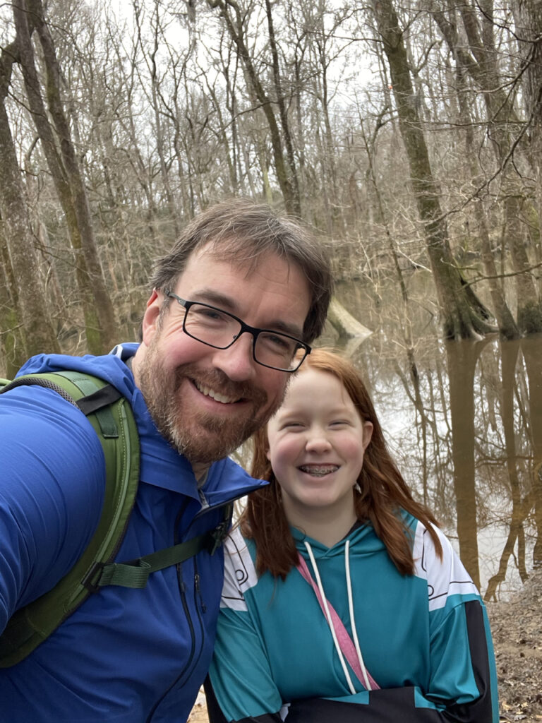 Cameron and myself hiking in the rain at Wise Lake off the Oakridge Trail in Congaree National Park. Photo taken in the rain, by the water, both of us wearing rain gear.