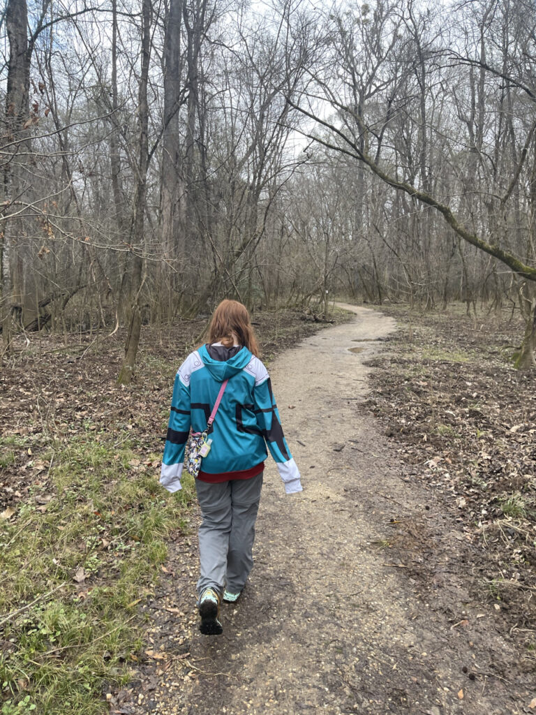 Cami walking down a muddy background trail in Congaree National Park. Taken in February, the trees where barren and the ground muddy. 