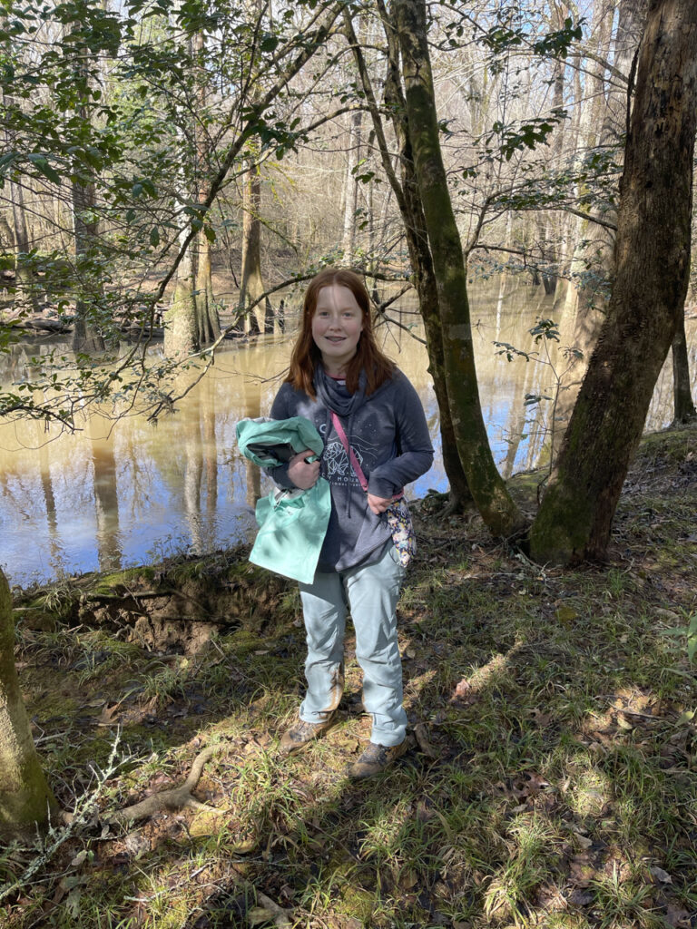 Cameron standing by a river deep in the forest of Congaree National Park. The rain had just stopped and the sun had made its way into the forest. 