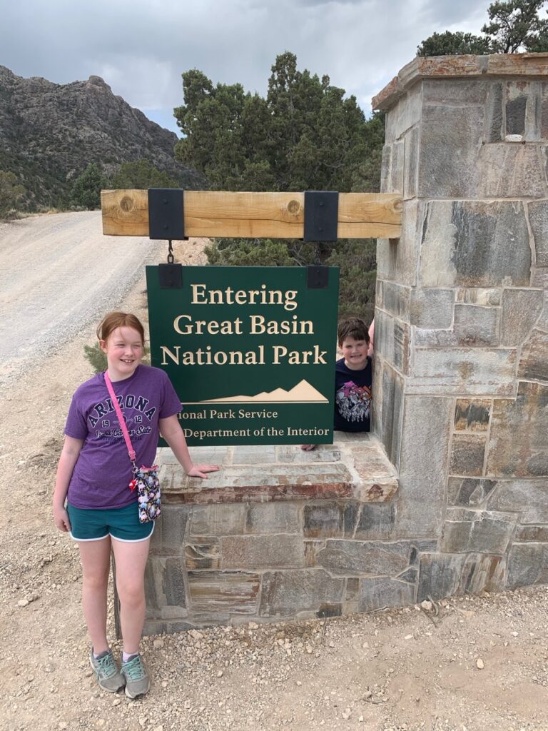 Cameron and Collin in front and behind the sign to Great Basin National Park.