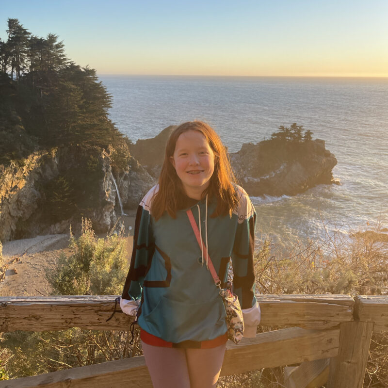 Cameron on the trail above McWay Falls at sunset over the pacific ocean.