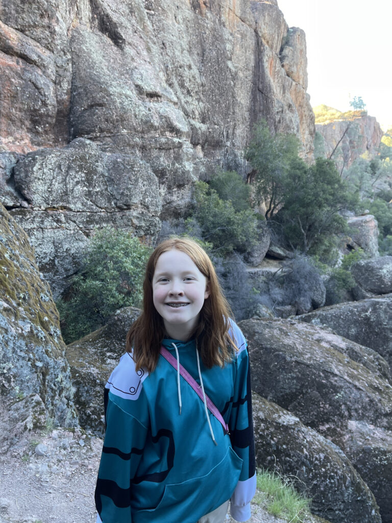 Cameron smiling after watching sunrise at the top of the mountain. Taken on the way back down in a narrow and rocky section of the Moss Spring Trial.