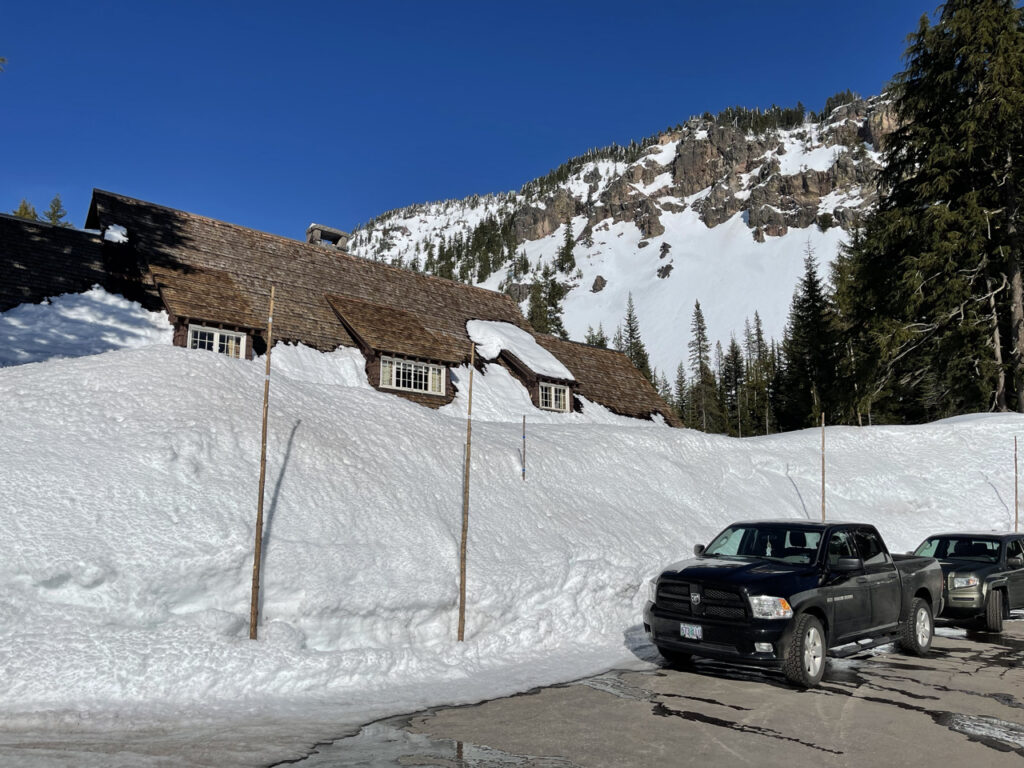 A winters photo taken in the parking lot of the visitors center. The snow is more then twice as tall as the truck parked and p to the second floor windows. Taken on a blue bird day at Crater Lake.