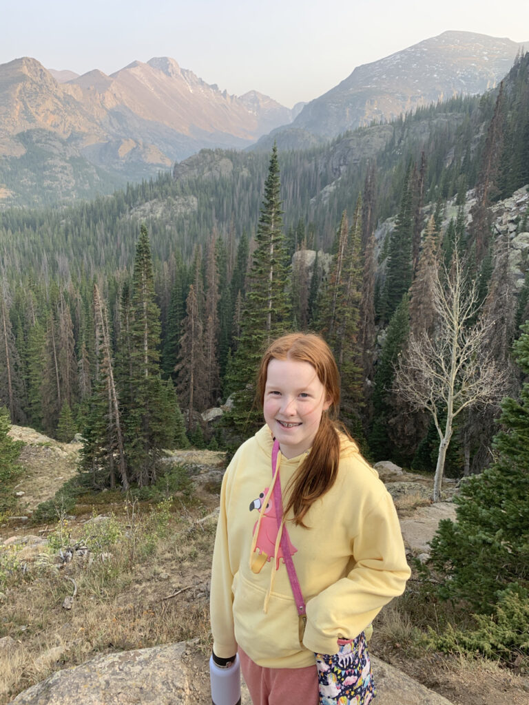 Cameron hiking on the Wind River Trail in Rocky Mountain National Park. Mountains and amazing light in the background.