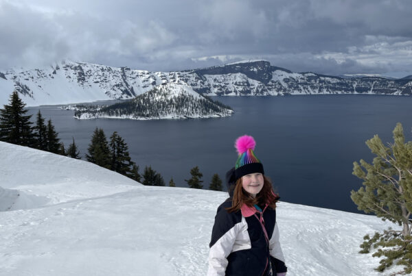 Cameron my red headed daughter standing on at least 30 feet of snow in hat, gloves and jacket at Crater Lake. Taken somewhere near Discovery Point on a cloudy winters day.