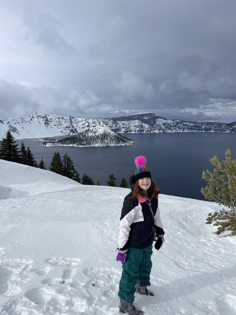 Cameron my red headed daughter standing on at least 30 feet of snow in hat, gloves and jacket at Crater Lake. Taken somewhere near Discovery Point on a cloudy winters day.