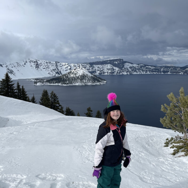 Cameron my red headed daughter standing on at least 30 feet of snow in hat, gloves and jacket at Crater Lake. Taken somewhere near Discovery Point on a cloudy winters day.