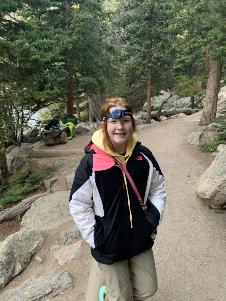 Cameron on the loop trail of Bear Lake, just after sunrise still wearing her headlamp from the pre-dawn hike.