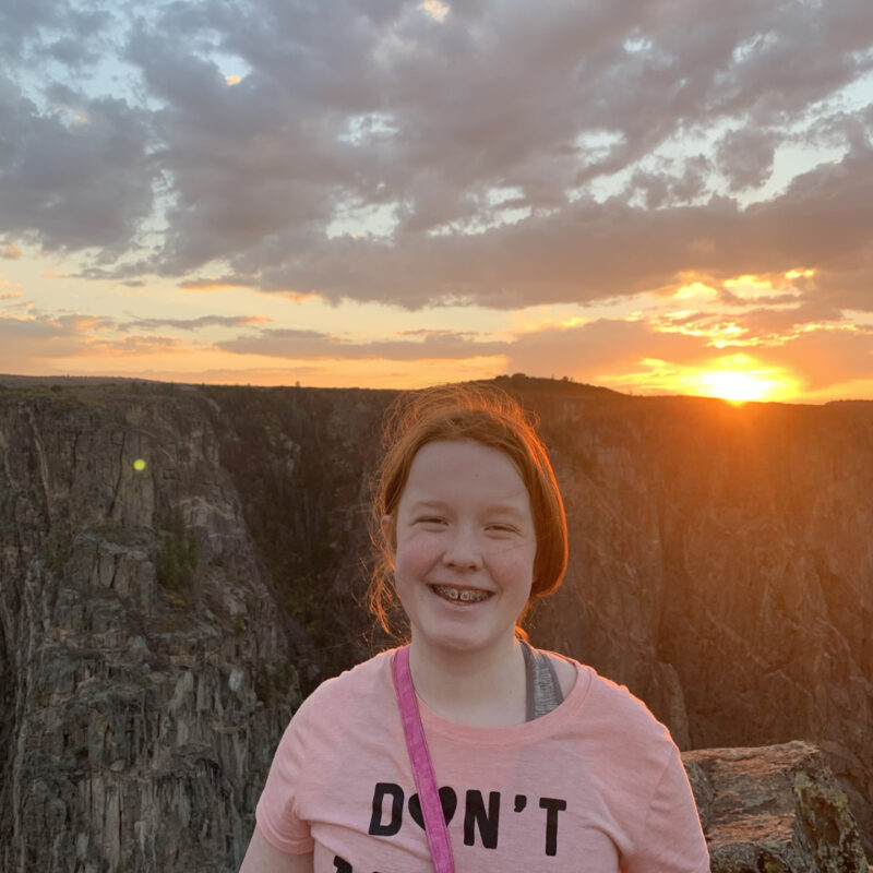 Cameron Standing up at sunset, with her red hair glowing for the last orange light of the day. Taken at the top of The Narrows Trails in Black Canyon of the Gunnison.