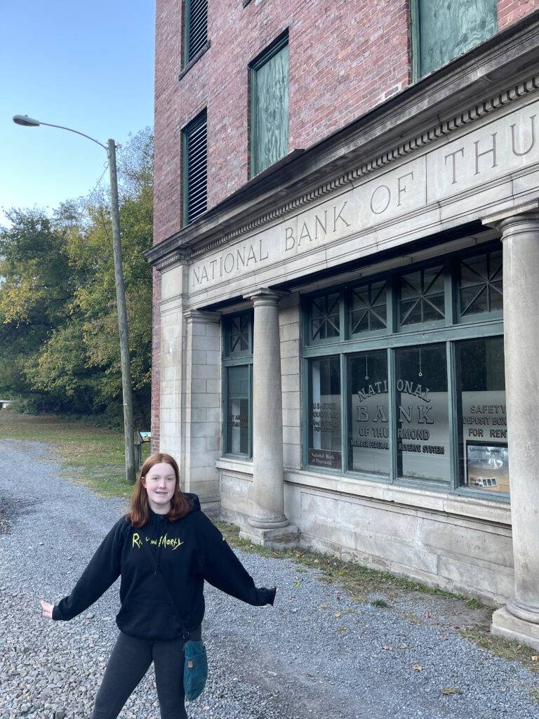 Cameron smiling next to the old National Bank of Thurmond, in the history and mostly abandoned down of Thurmond.