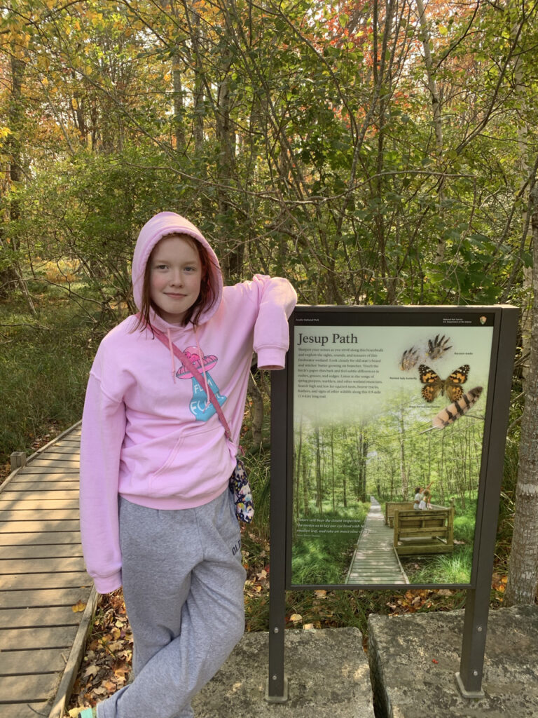 Cameron leaning on the sign to Jesup Path, in Acadia National Park.