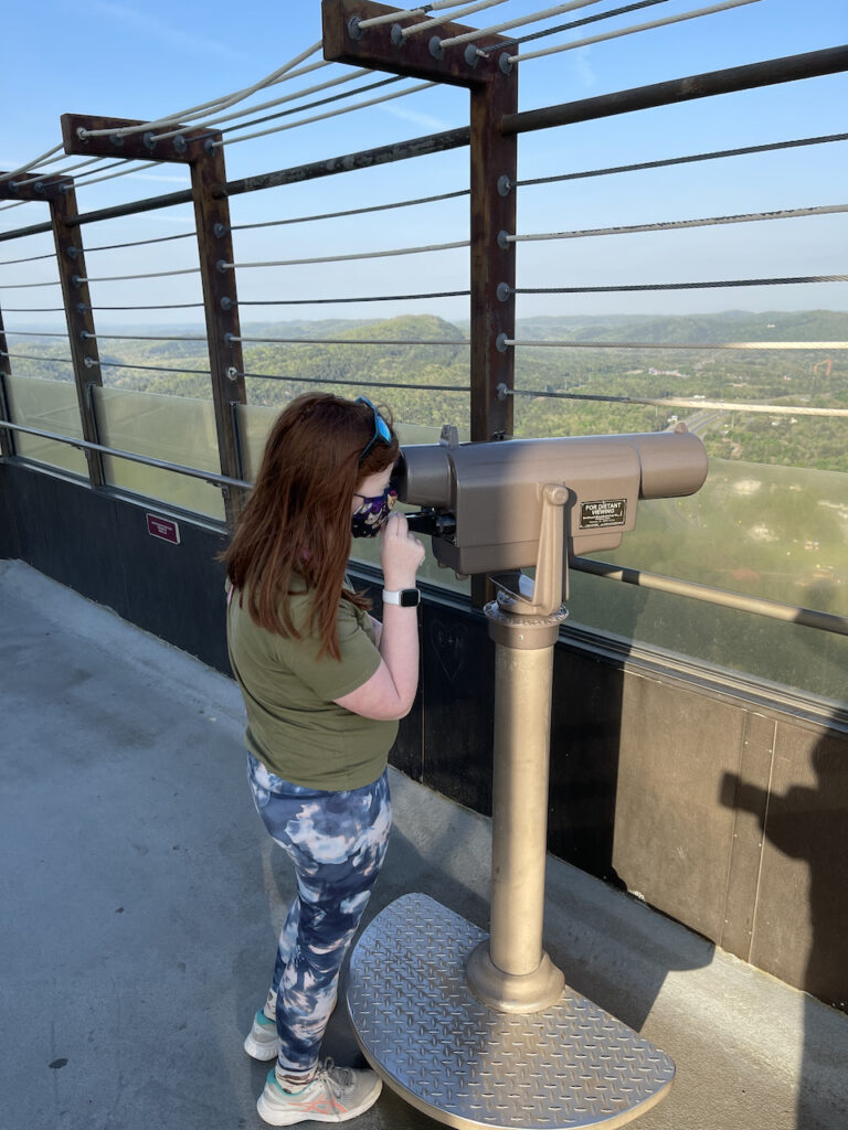 Cameron looking through binoculars on top of the Hot Springs Mountain Tower.